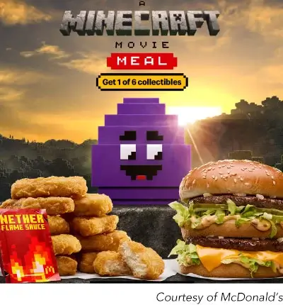 A promotional graphic for a McDonald’s ‘Minecraft Movie Meal’. In the center, there is a large, purple, cube-shaped collectible toy with a pixelated face, resembling a character from the Minecraft video game. In the foreground on the left, there is a stack of chicken nuggets, with a package of ‘NETHER FLAME SAUCE’ sitting on top. On the right, there is a large double cheeseburger. The background is a landscape from the Minecraft game, with a pixelated mountain and a sunset. A banner at the top reads ‘A MINECRAFT MOVIE MEAL’ and a smaller yellow banner below it reads ‘Get 1 of 6 collectibles’. The bottom right corner has a caption that reads ‘Courtesy of McDonald’s’.
