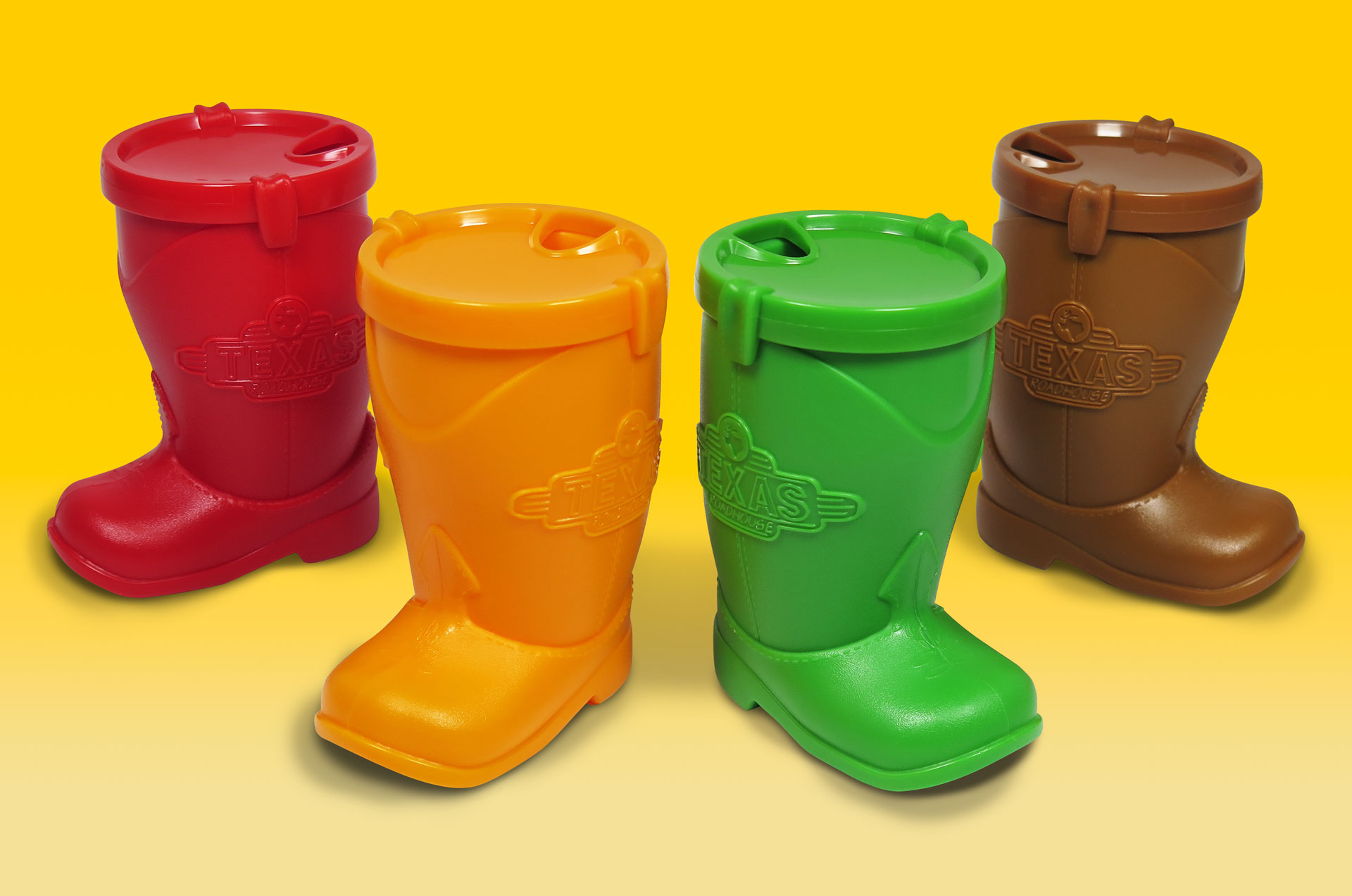 A group of four plastic boot-shaped cups in red, orange, green, and brown, each embossed with the Texas Roadhouse logo.