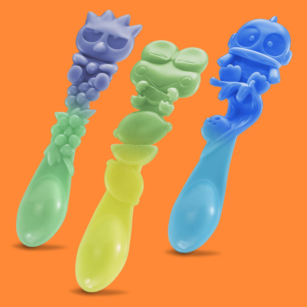 Three color-changing Sanrio-themed spoons featuring Badtz-Maru, Keroppi, and Badtz-Maru characters, displayed against an orange background.